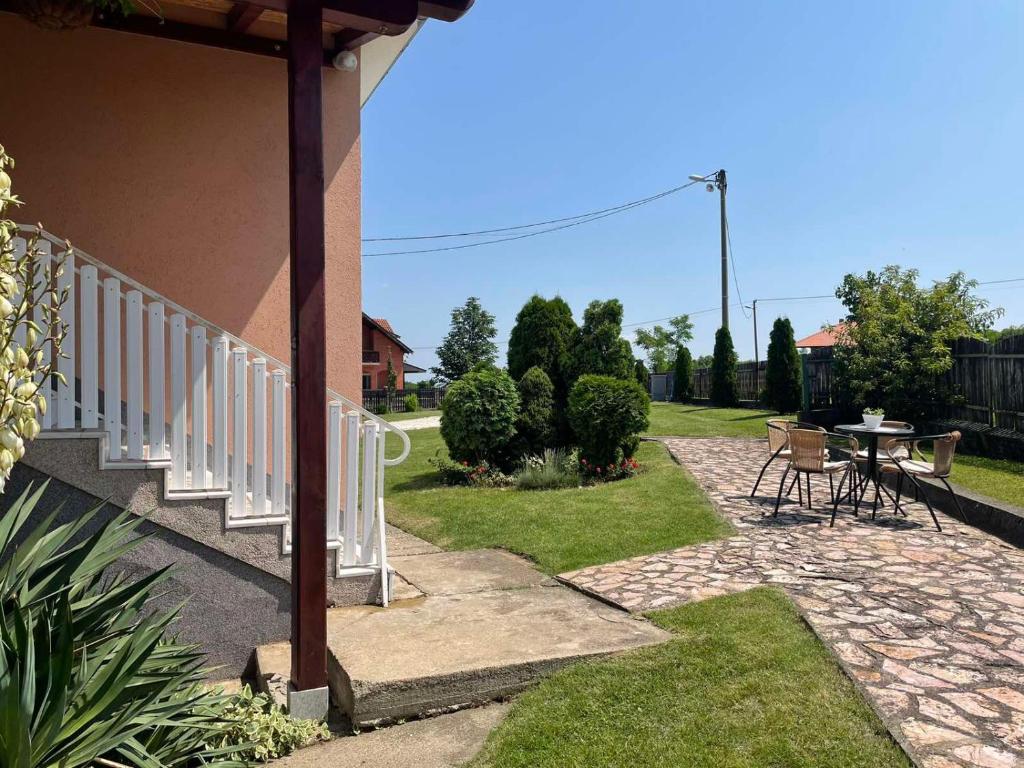 un patio con barandilla blanca, mesa y sillas en Starčević apartmani Orašac Aranđelovac, en Orašac