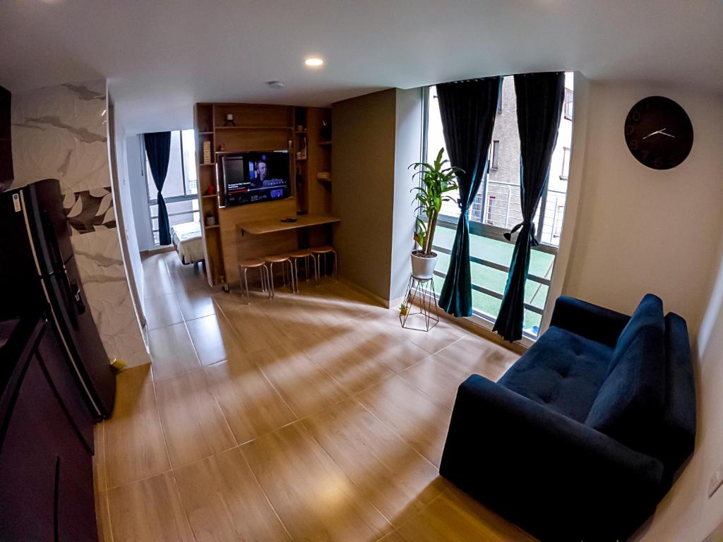sala de estar con sofá azul y TV en Cómodo apartamento tipo Loft en centro de Bogotá 5, en Bogotá