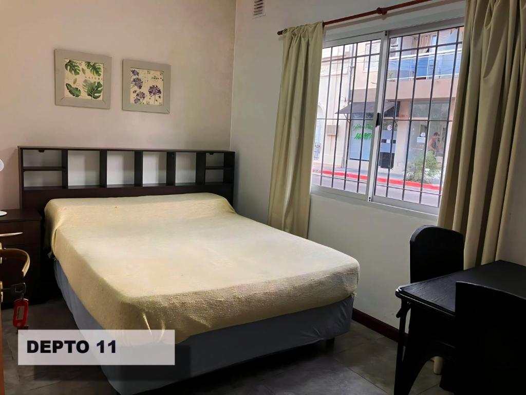 a small bedroom with a bed and a window at Sarmiento Monoambiente in Concordia
