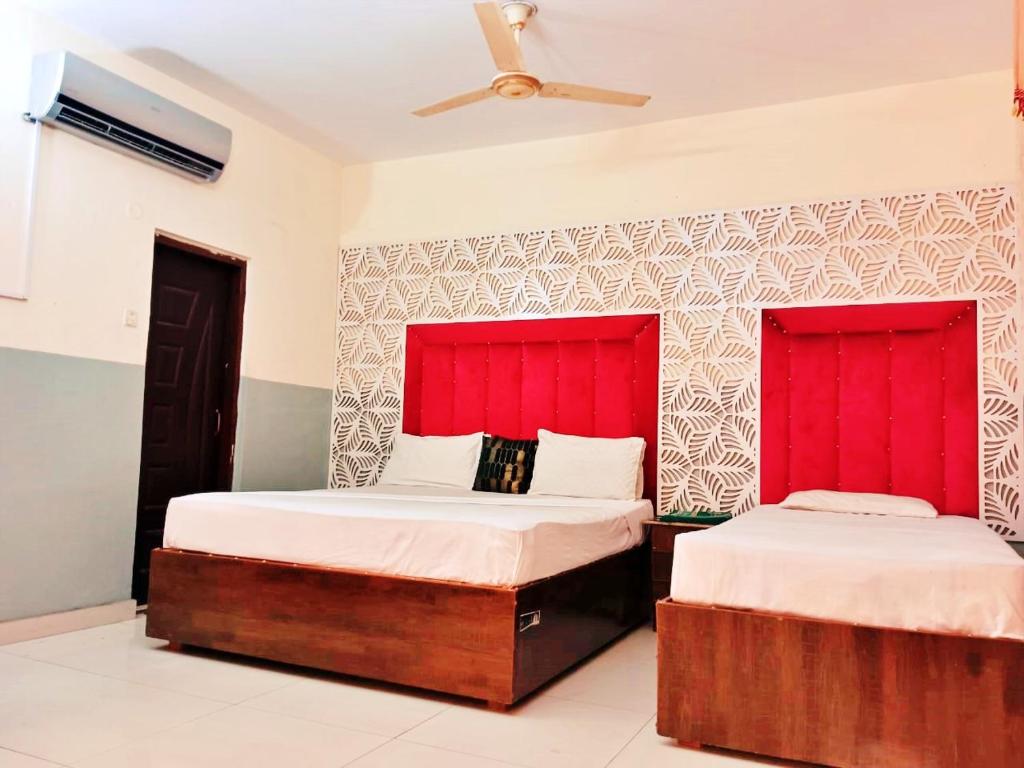 2 camas en una habitación con cabeceros rojos en Moon Soon Hotel, en Lahore