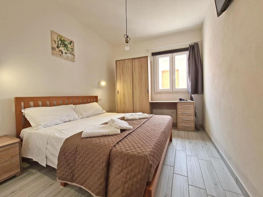 um quarto com uma cama com duas toalhas em Civico 14 Apartment 2 em Monserrato