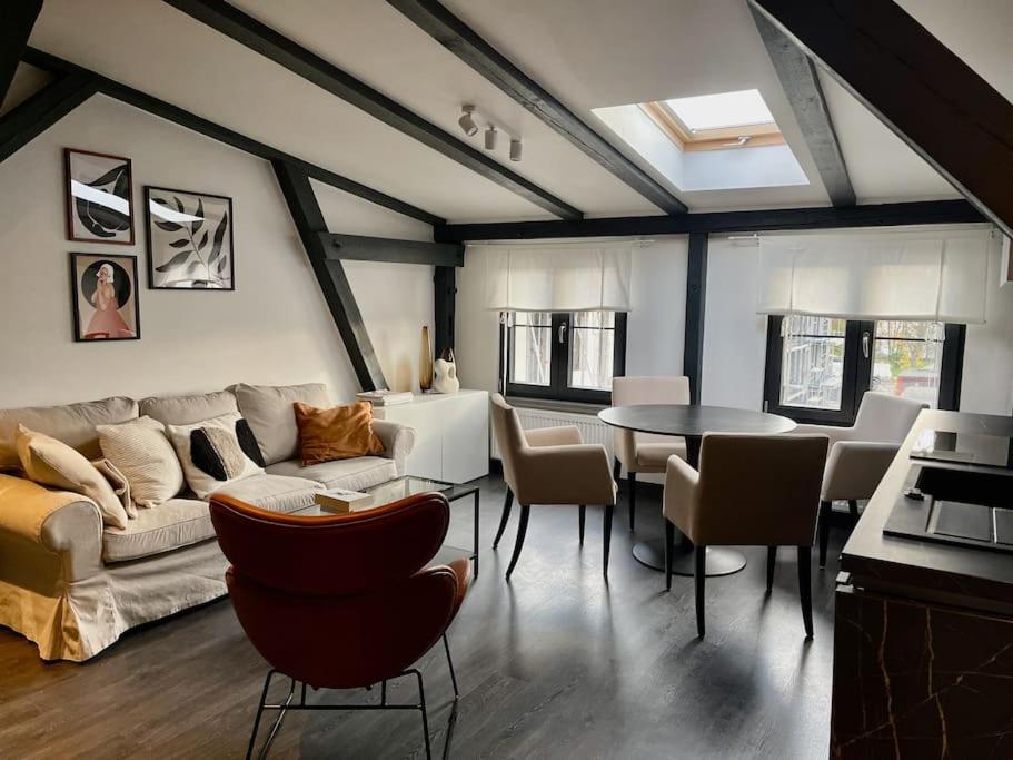 a living room with a couch and a table and chairs at Bielawy Suite in Bydgoszcz