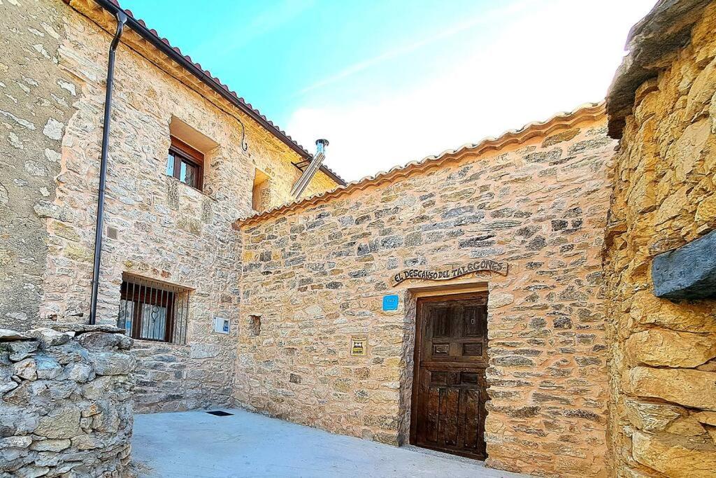 an old stone building with a wooden door in it at El Descanso del Talegones in Torrevicente