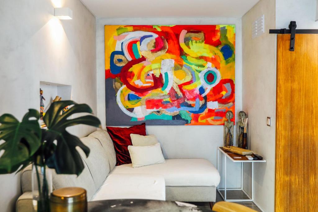 una sala de estar con un sofá blanco y una pintura en Casa do Sal, en Albufeira