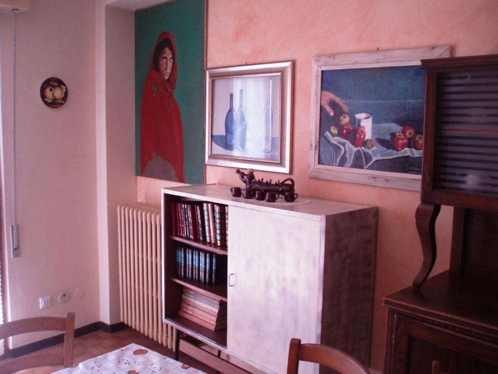 Cassina ValsassinaにあるAppartamento Colomboの本棚と壁画のある部屋
