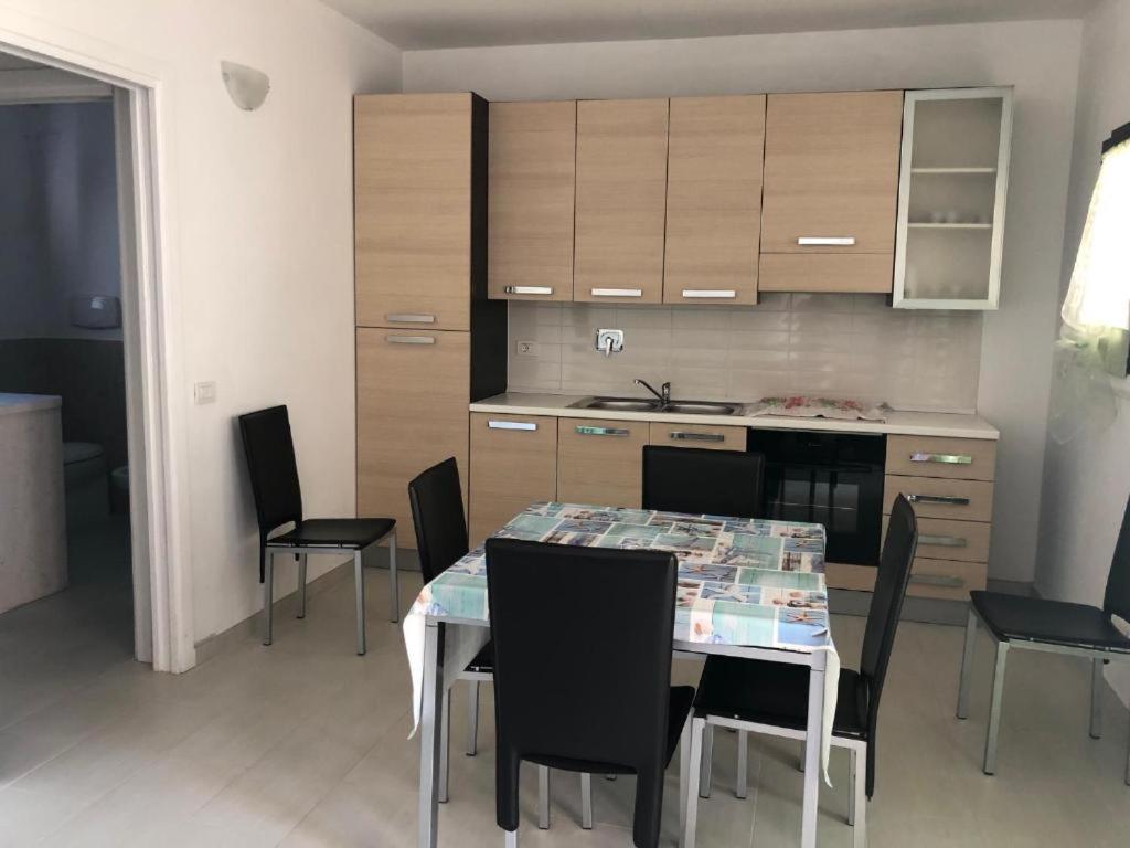 a kitchen with a table and chairs in a room at Casa Vacanza Budoni Mare in Budoni