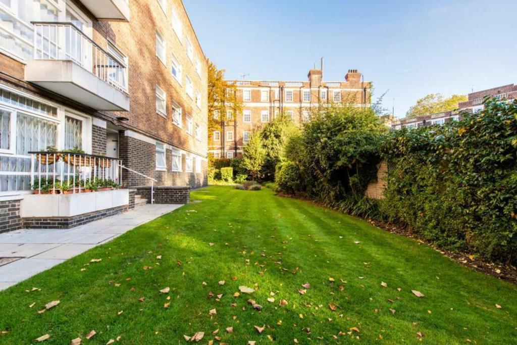 Ultra Luxury Central London 3Bed Apartment في لندن: حديقة خضراء أمام المبنى