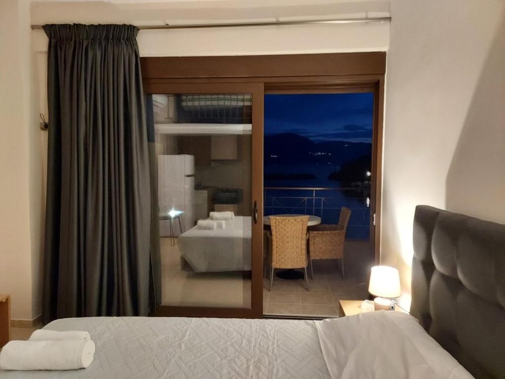 a bedroom with a bed and a view of a room at Prego Living Apartments in Vathí