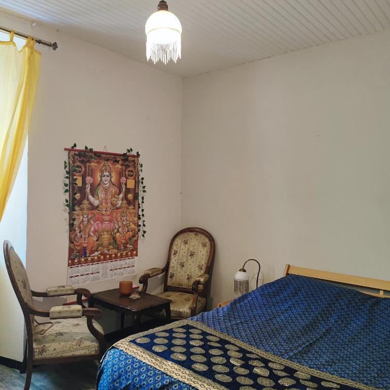 une chambre avec un lit et un tableau au mur dans l'établissement Chambres d'hôtes dans Mas avec jardin en bord de rivière, à Saumane