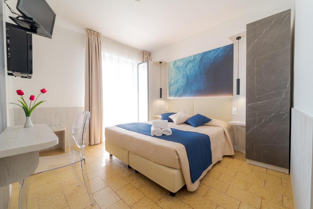 a bedroom with a bed and a desk and a television at Hotel Beach in Tortoreto Lido