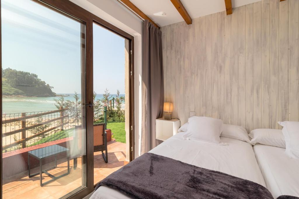 a bedroom with a bed and a view of the ocean at Hotel SanMar in Cóbreces