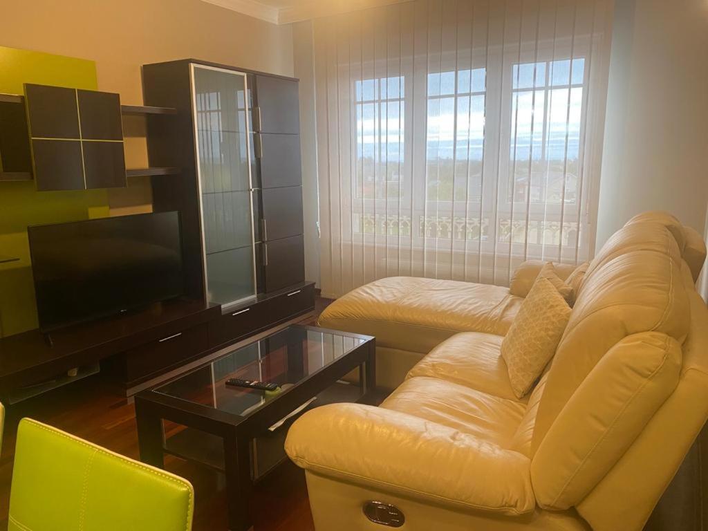 a living room with a couch and a tv at Rocas Brancas in Ribadeo