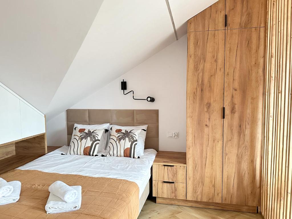 um quarto com uma cama e um armário de madeira em DMK Oak Studio near Warsaw-Modlin Airport em Nowy Dwór Mazowiecki