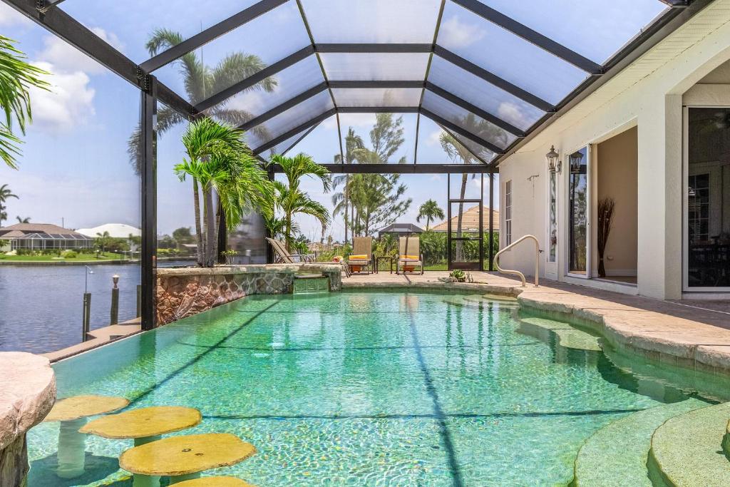 einen Innenpool mit Glasdecke und einen Pool in der Unterkunft Gulf Access, Heated Pool and Spa, Sleeps 8! - Villa Baydream Believer - Roelens Vacations in Cape Coral