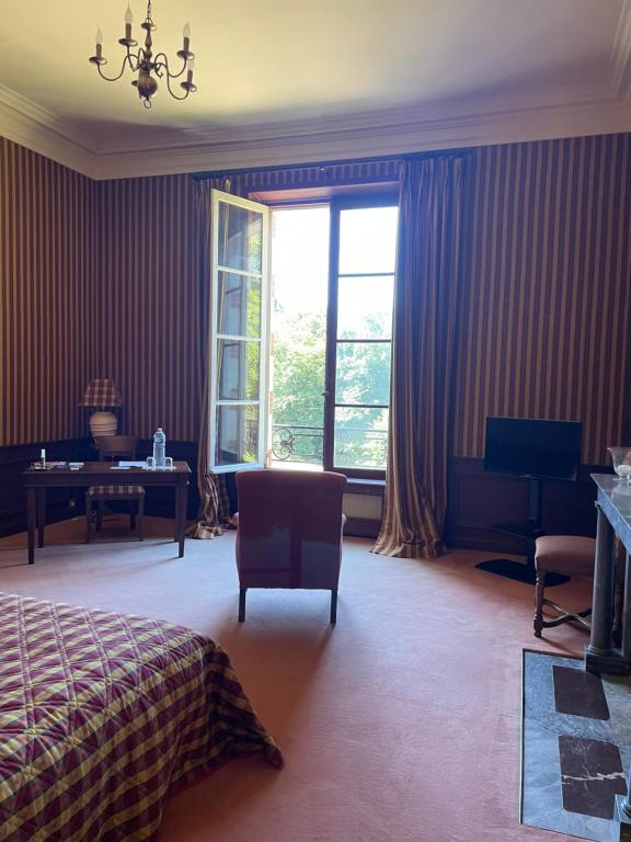 una camera con letto, scrivania e finestra di Château de Praslins a Nogent-sur-Vernisson