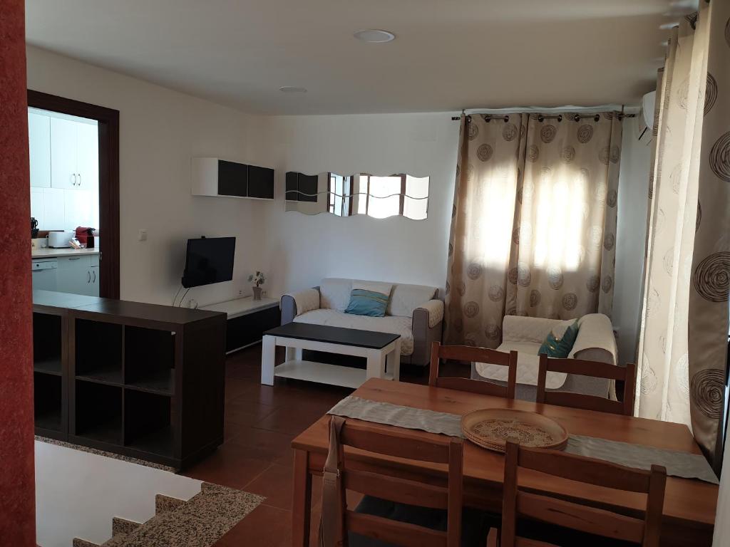 sala de estar con mesa y sofá en Alojamiento Rural Mirador del Valle, en Baños de la Encina