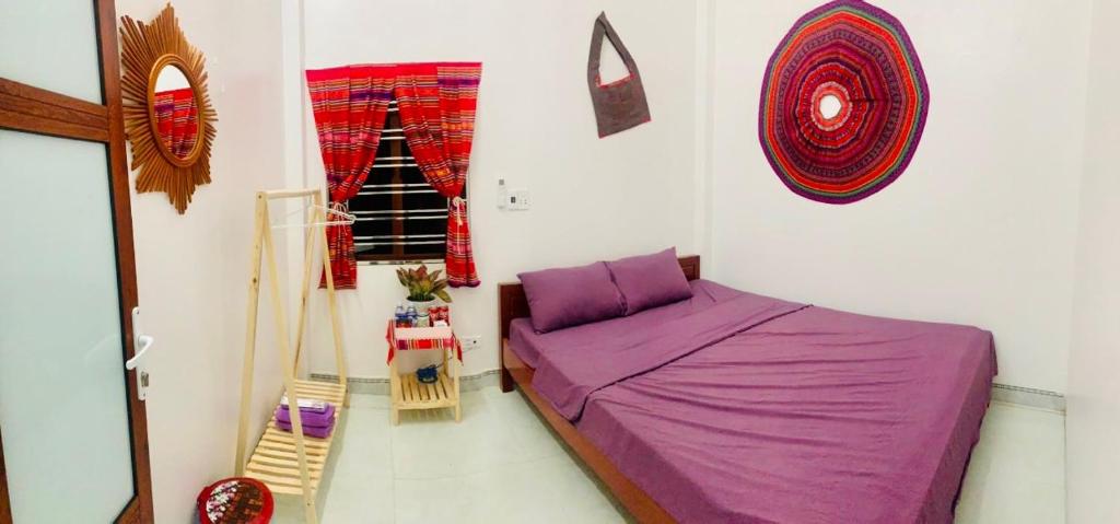 ein Schlafzimmer mit einem lila Bett und einem Fenster in der Unterkunft Pết house Mộc Châu in Mộc Châu
