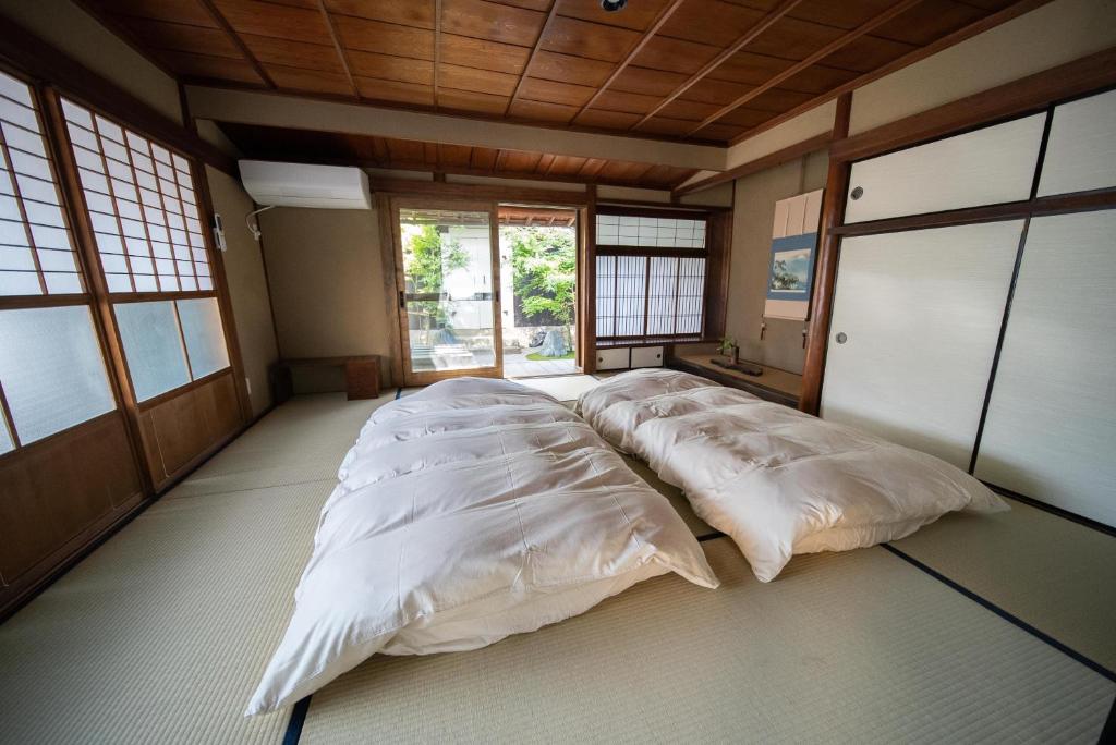 Postel nebo postele na pokoji v ubytování Castle Town Contemporary Ryokan 天籟 - TENRAI -