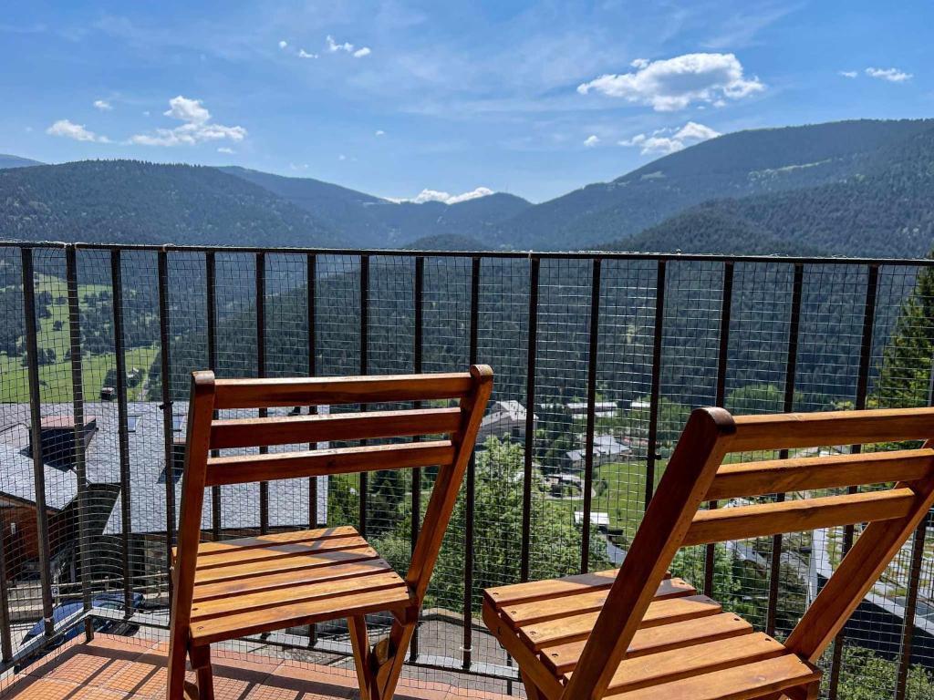 2 sillas de madera en la parte superior de un balcón en El Mirador de La Molina en La Molina