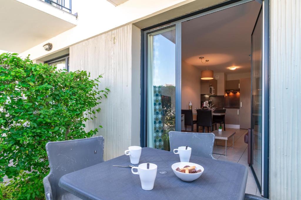 a table with a bowl of food on it on a patio at Les Thermes 508 - Appt avec piscine partagée in Concarneau