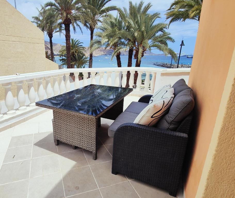 uma varanda com mesa, cadeiras e palmeiras em Amazing View in Tenerife Royal Garden em Playa de las Americas