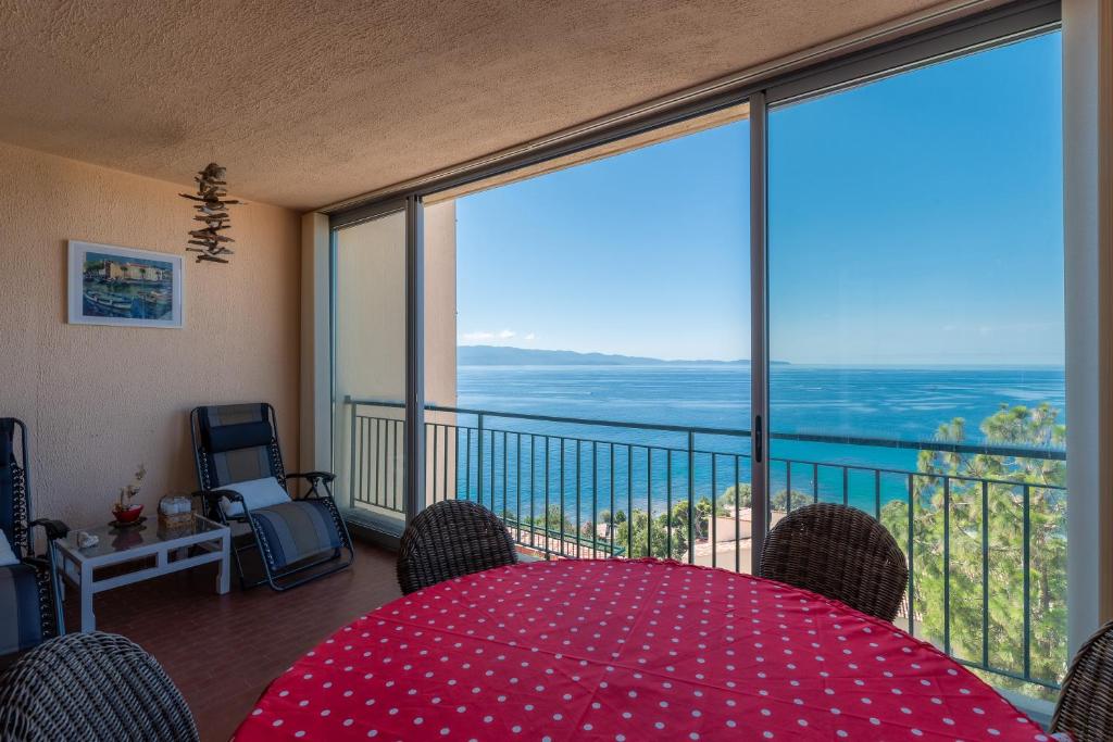 Cette chambre dispose d'une table et d'un balcon avec vue. dans l'établissement Standing climatisé vue mer, à Ajaccio