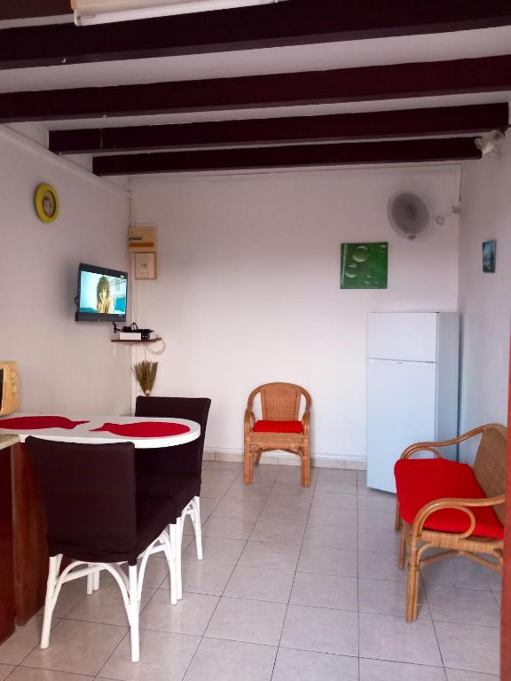 a living room with a table and chairs and a tv at Appartement d&#39;une chambre avec balcon et wifi a Le Vauclin a 3 km de la plage in Le Vauclin