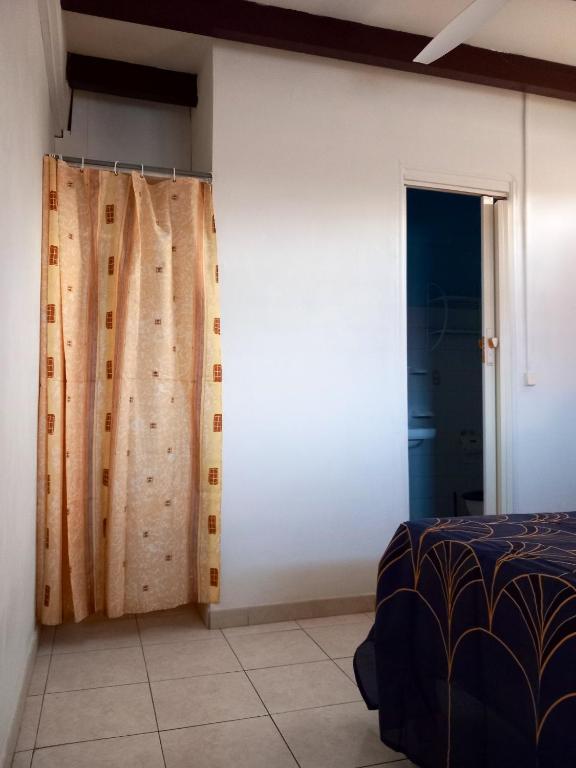 a bedroom with a bed and curtains in it at Appartement d&#39;une chambre avec balcon et wifi a Le Vauclin a 3 km de la plage in Le Vauclin