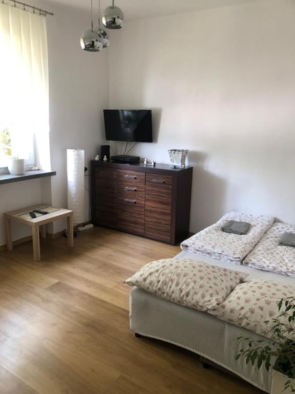 a bedroom with a bed and a flat screen tv at Apartament Aga1 in Oświęcim
