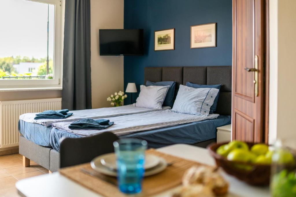 a bedroom with a bed with blue walls and a table at Przystań Nemo in Ustka
