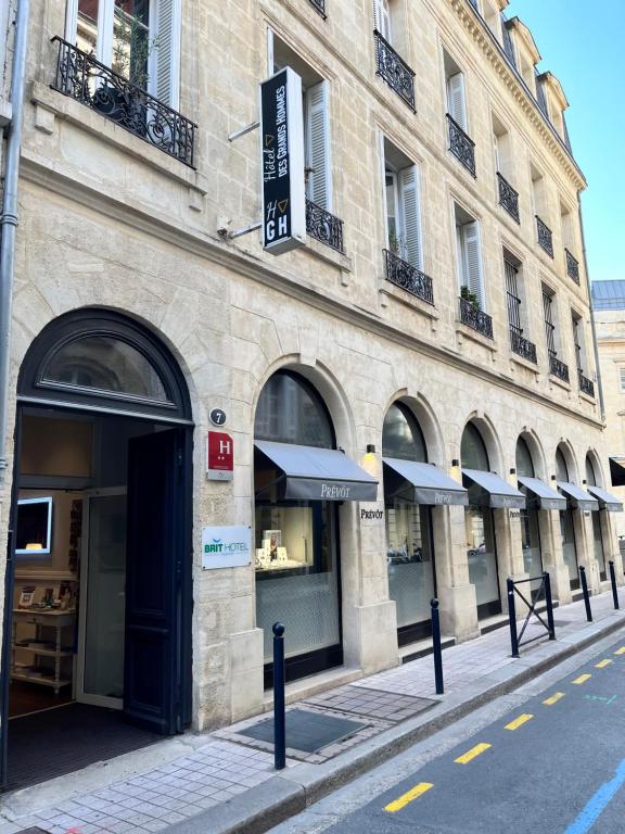 un edificio en una calle de la ciudad con una tienda en Brit Hotel Des Grands Hommes - Bordeaux Centre en Burdeos