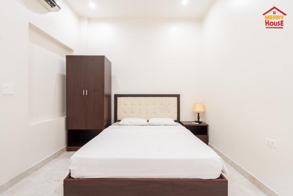1 dormitorio con 1 cama grande y armario de madera en Merry House Bạch Dương, en An Khê
