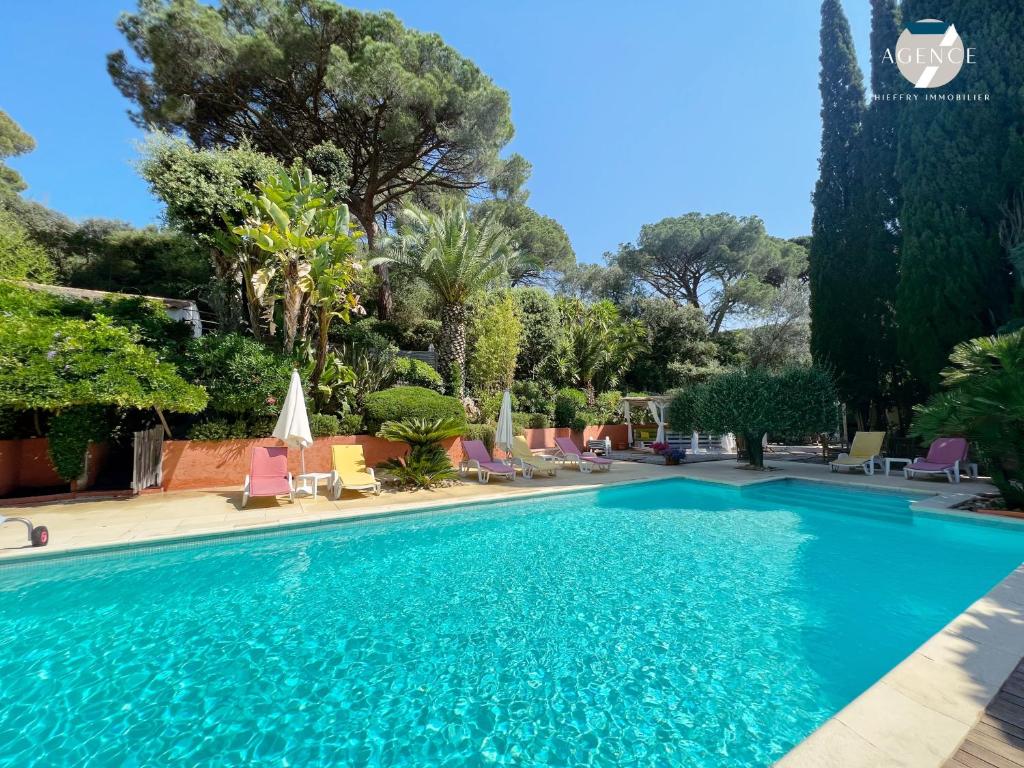 - une piscine dans un complexe avec des chaises et des arbres dans l'établissement Villa Pura Vida, à Sainte-Maxime