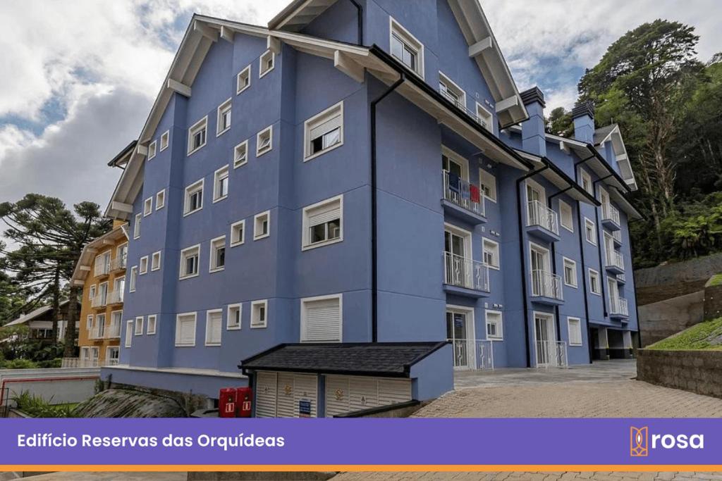 een groot blauw gebouw met aventh floor bij Rosa Edifício Reservas das Orquídeas in Gramado