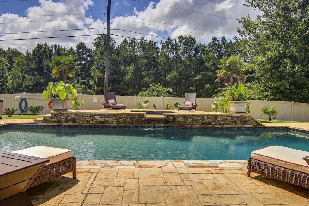 a swimming pool with lounge chairs in a backyard at The REZORT-Ideal for Exclusive Events Feat. Pool, Gym, Fire Pit & More! in Lawrenceville