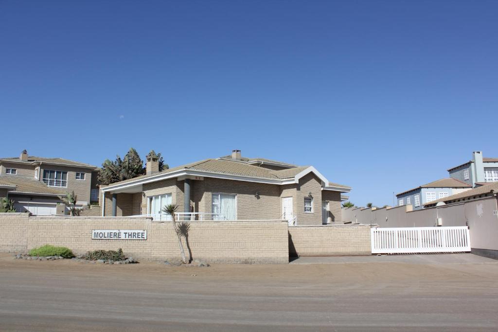 a house with a brick fence in front of it at Muller's Self Catering - a cozy home from home! in Swakopmund