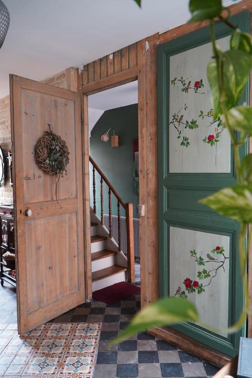een open deur in een kamer met een trap bij chambres d'hôtes Le Carillon in Bergues