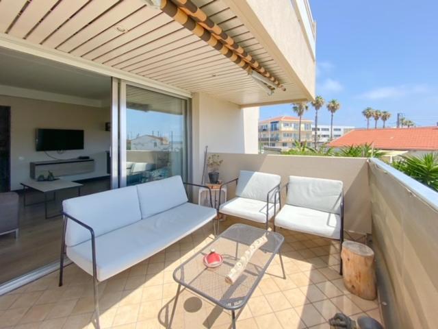 d'une terrasse avec un canapé et des chaises sur un balcon. dans l'établissement Charmant appartement proche des plages, à Antibes