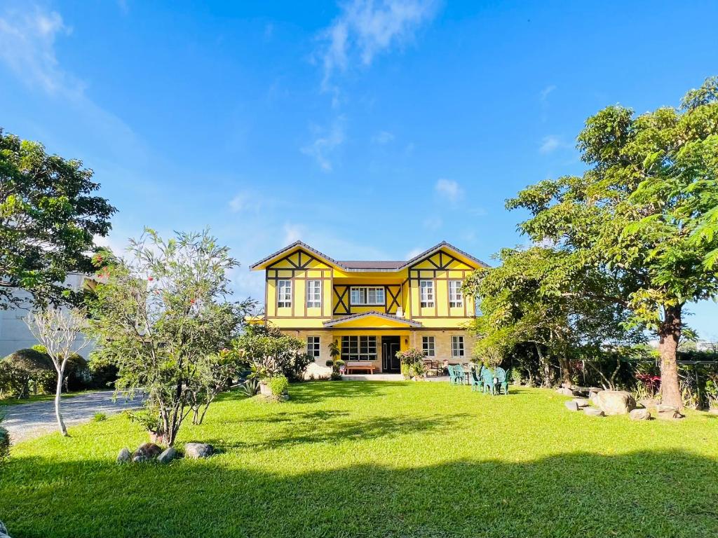 台東市的住宿－台東普羅旺斯莊園民宿 Provence Inn，绿色草坪上的大型黄色房子