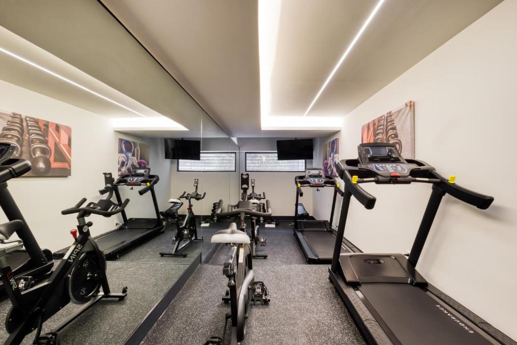 A compact gym is equipped for treadmill, bike, and cross-training workouts.