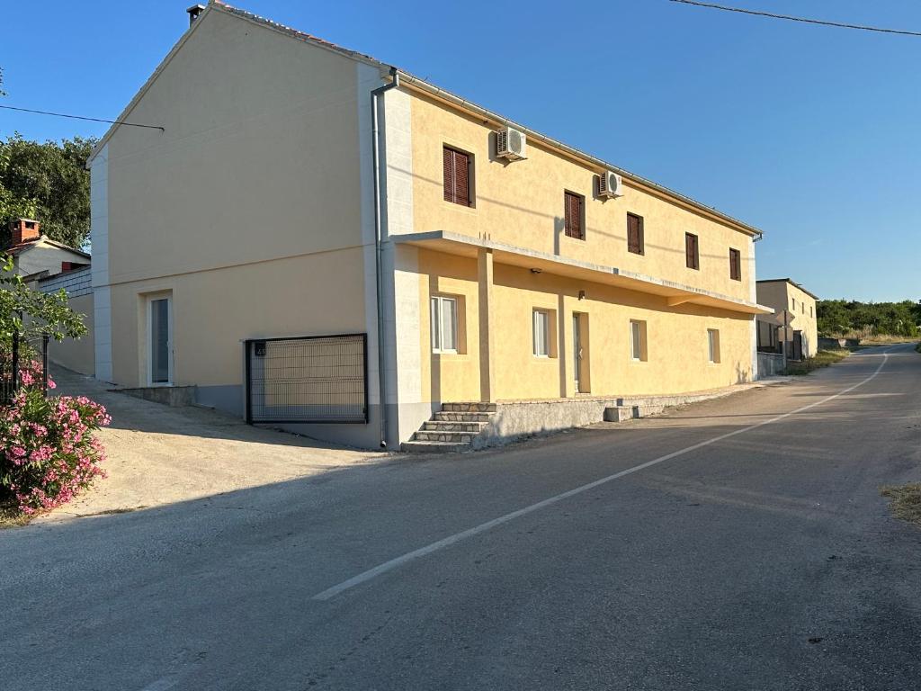 a building with a garage on the side of a road at Mimi&Nina in Prović