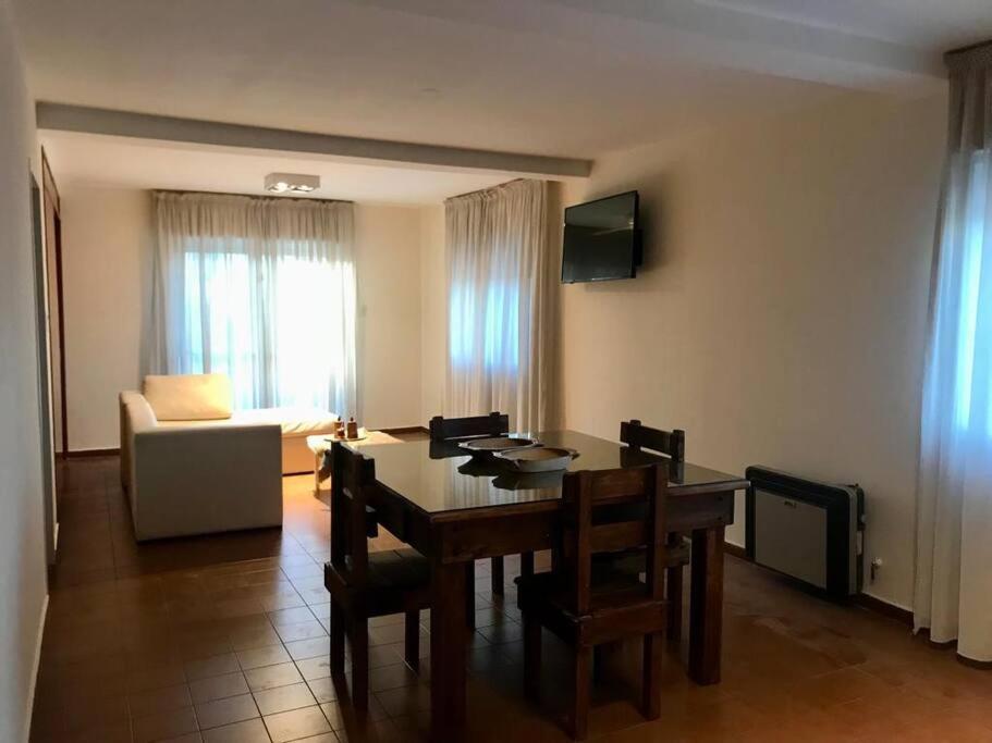 Una sala de estar con una mesa y sillas y un sofá. en Amplio Departamento Céntrico, en San Juan