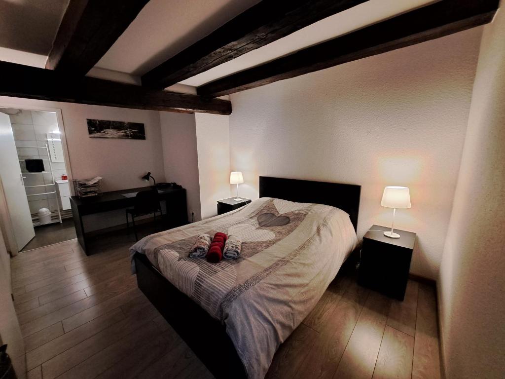 - une chambre avec un lit avec deux chaussures dans l'établissement Les Colombages, à Colmar