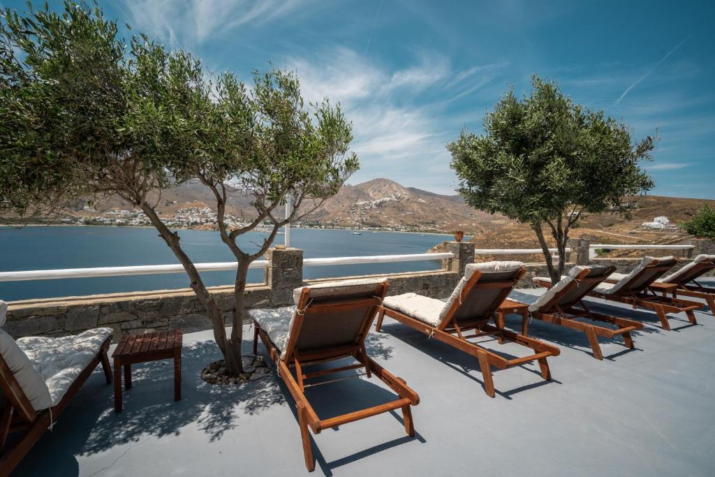 a row of chairs sitting next to a body of water at Astrio Suites in Livadi