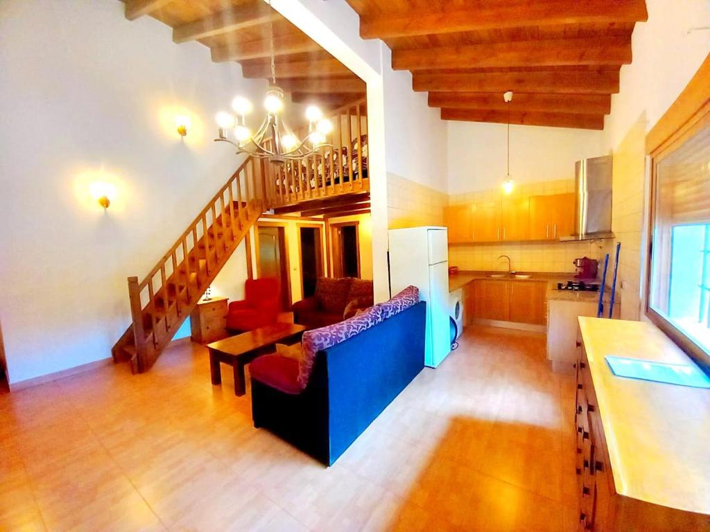 - un salon avec une cuisine et un escalier dans une maison dans l'établissement Casas Rurales Venta Ticiano, à El Morrion
