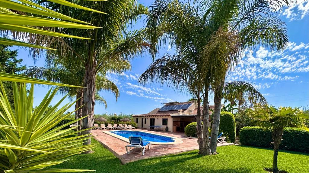 dom z basenem i palmami w obiekcie Villa Erythrina w mieście Alhaurín el Grande