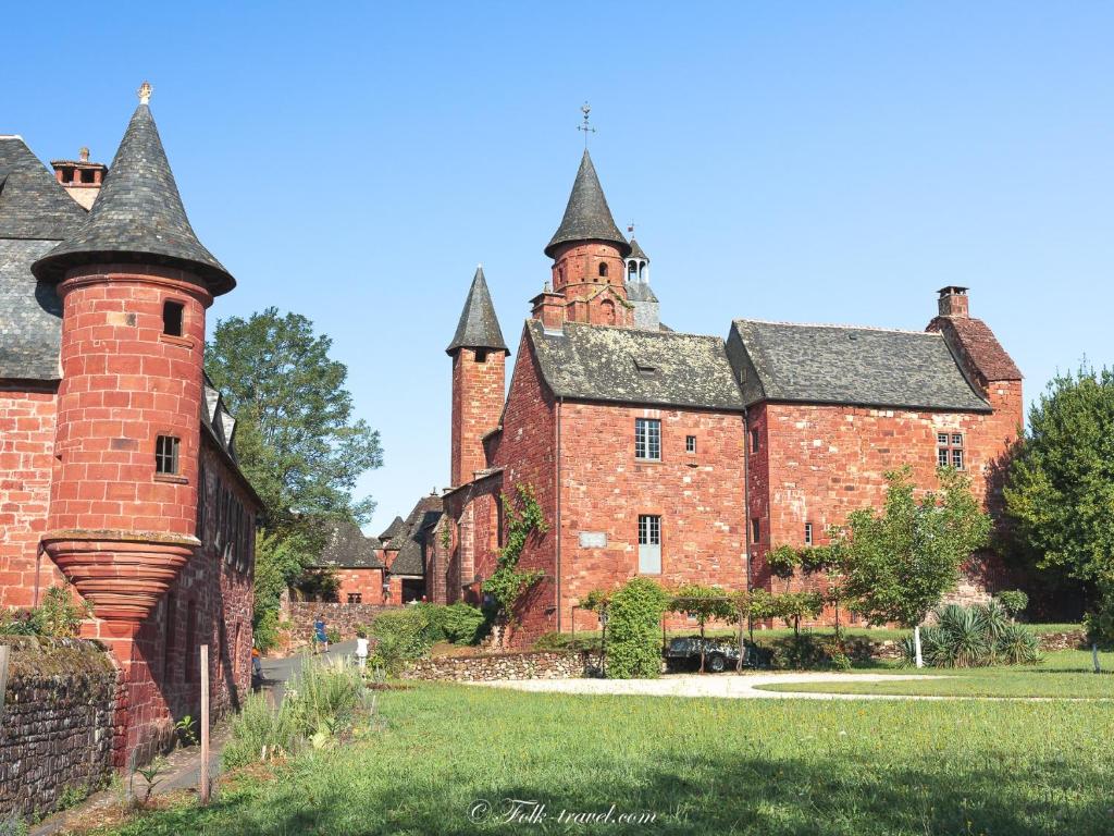 an old red brick building with two turrets at Gîte "le haut des Poujades" in Reilhaguet