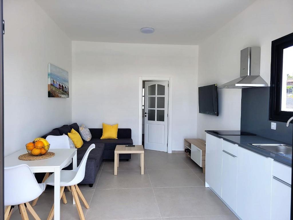 sala de estar con sofá azul y mesa en Apartamentos Falcón en Tinajo