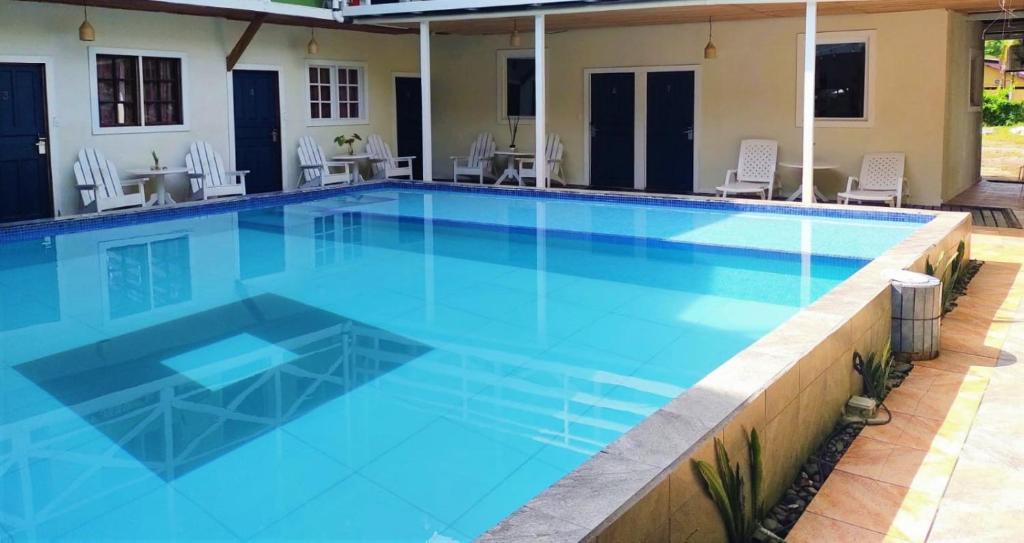 a large swimming pool with blue water at Lizard King Hotel & Suites in Puerto Viejo