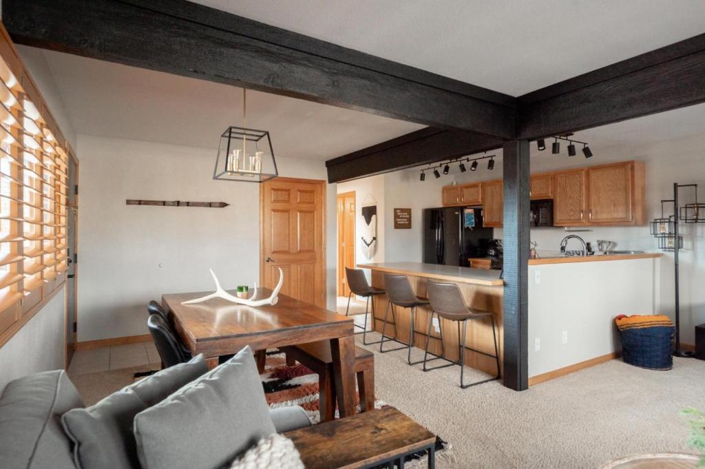 a living room with a table and a kitchen at Mod MTN Must - Steps from Shuttle - Silverthorne in Silverthorne
